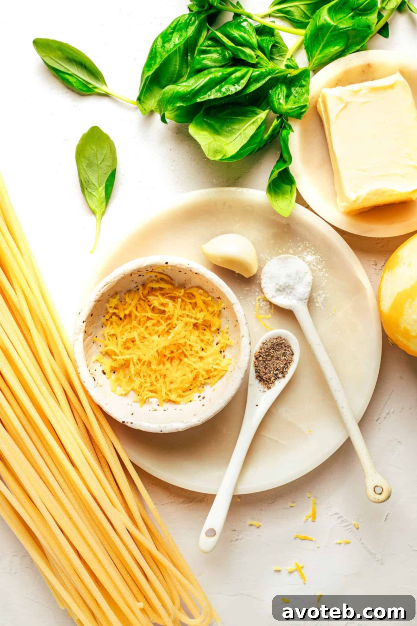 Lemon basil butter pasta ingredients including fresh basil, butter, garlic, lemon, salt, pepper, and pasta