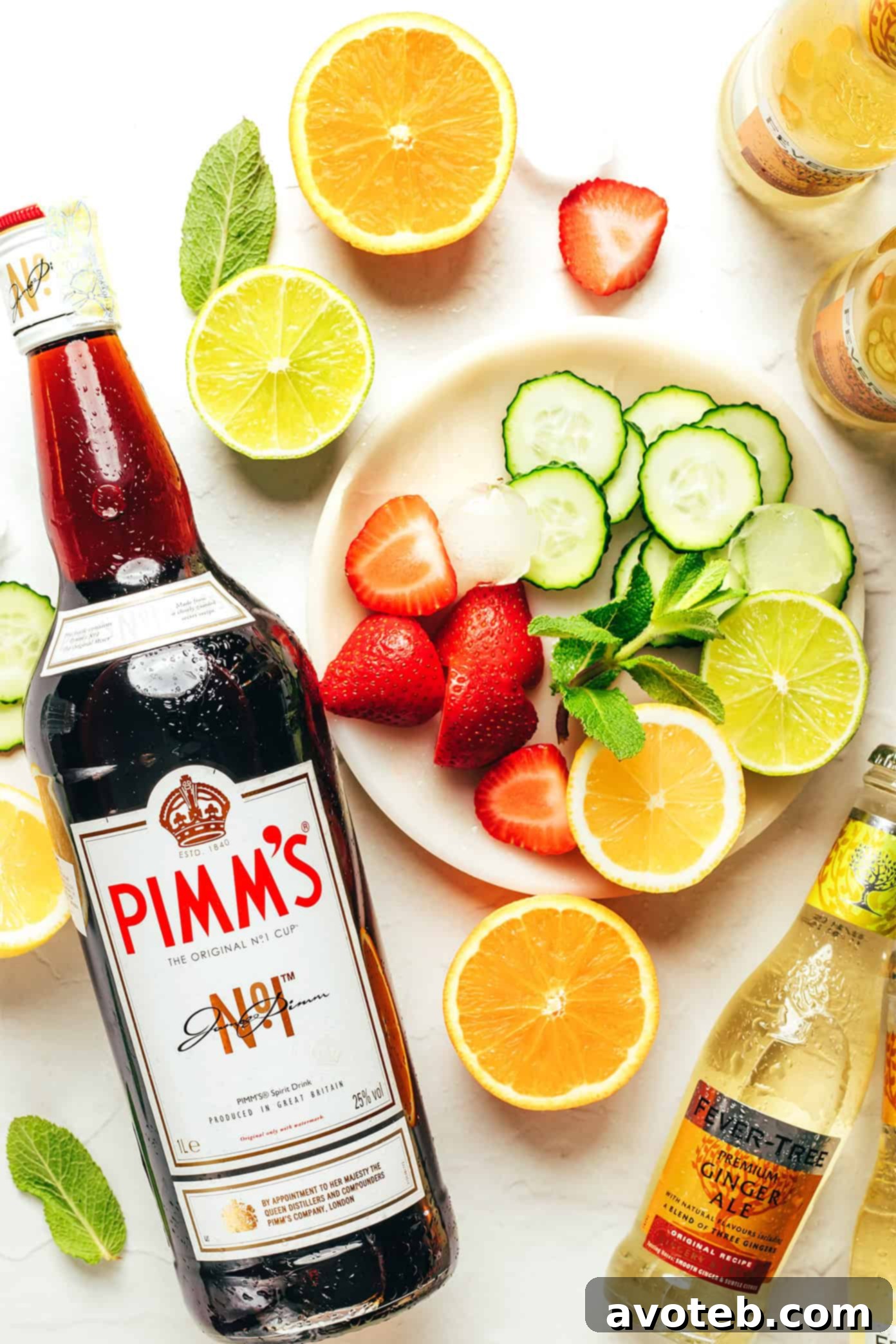 Two Pimm's Cup cocktails in highball glasses, filled with ice, fruit, cucumber, and mint