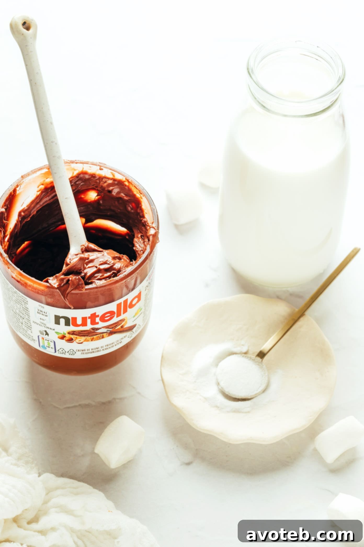Two mugs of Nutella hot chocolate with a jar of Nutella in the background.