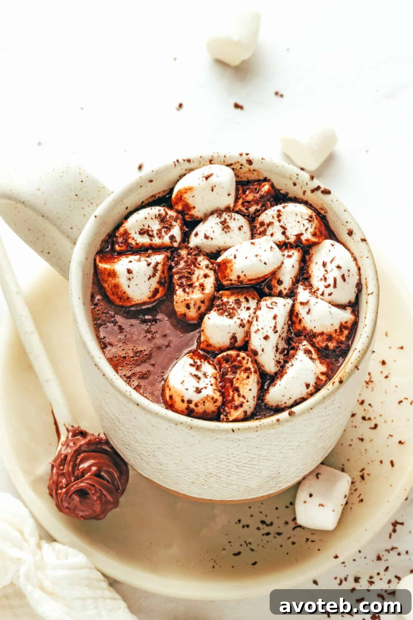 A mug of Nutella hot chocolate with toasted marshmallows and chocolate shavings.