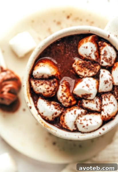 A detailed close-up of Nutella hot chocolate with whipped cream and chocolate shavings.