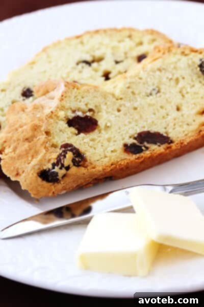 A top-down view of a rustic Irish Soda Bread loaf, displaying its perfectly scored cross and inviting golden crust.