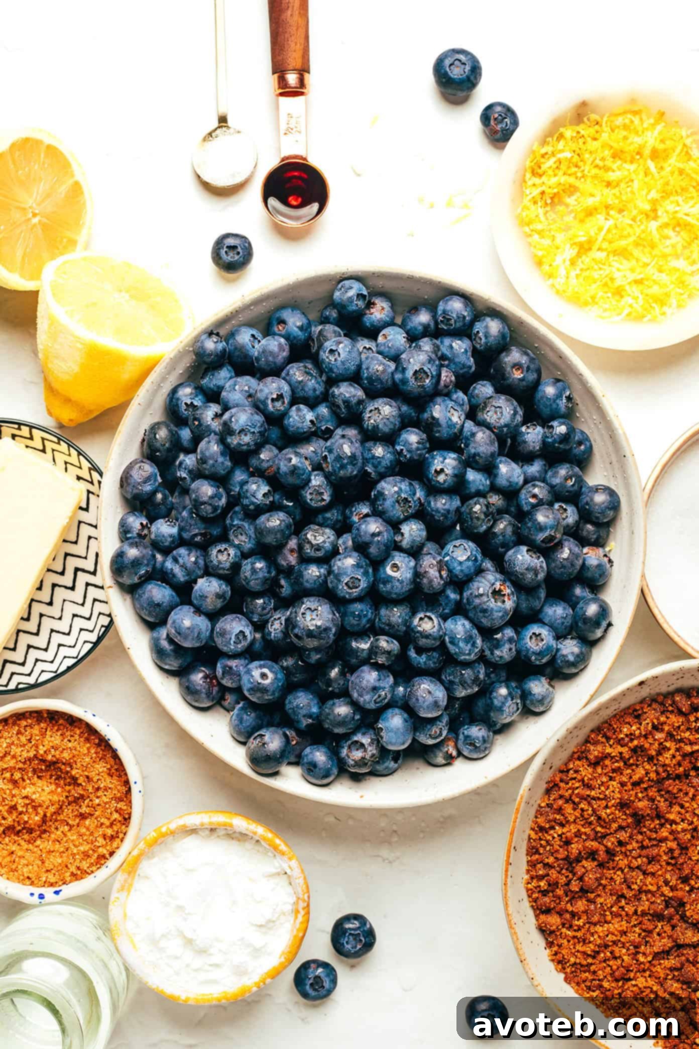 A close-up view of the no-bake blueberry tart filling being poured into the gingersnap crust in a tart pan, showing the vibrant color of the berries.