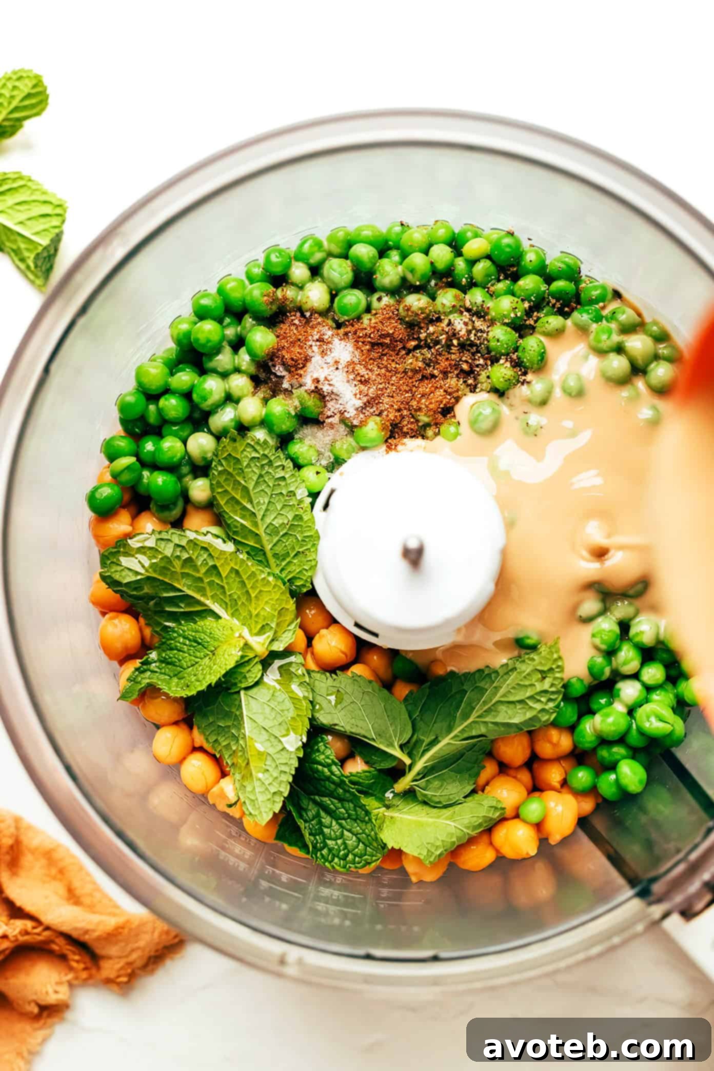 Vibrant Mint Pea Hummus 4 A vibrant green bowl of mint pea hummus, seen from above, garnished with fresh mint leaves and a swirl of olive oil, ready to be served.