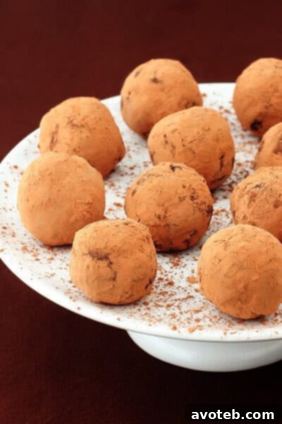 Close-up of perfectly rolled Bailey's Chocolate Truffles dusted with cocoa powder, ready to be enjoyed.