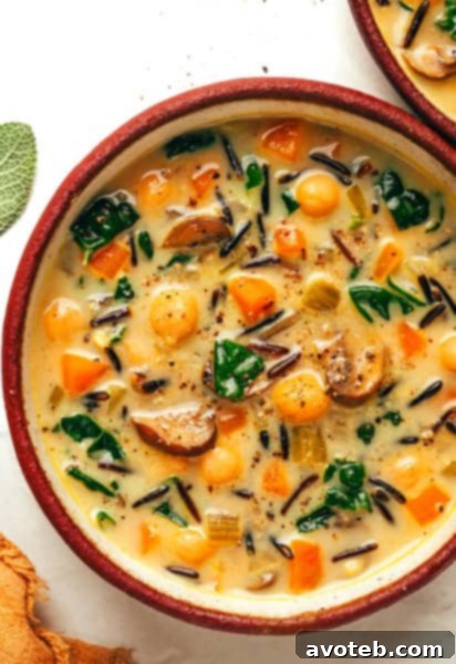 A bowl of creamy pumpkin wild rice soup with a spoon