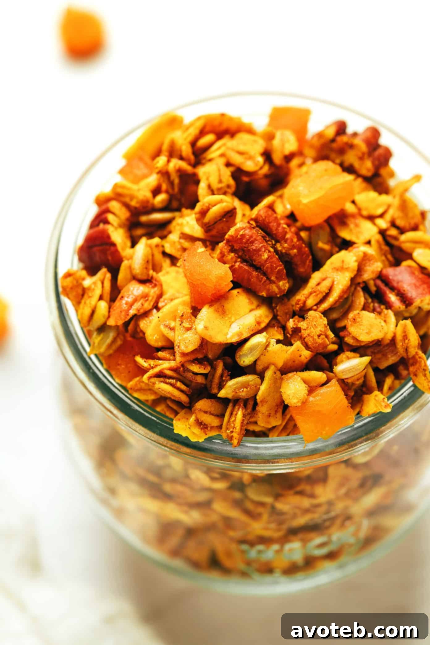 Golden Granola served with milk in a bowl, with some clusters on the side