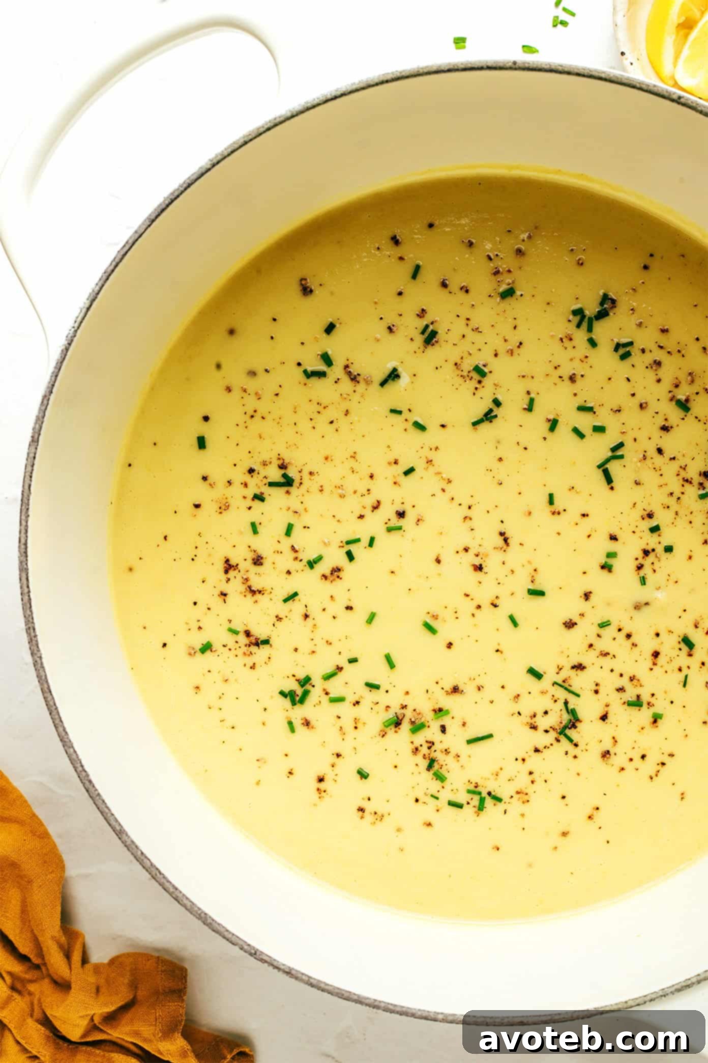 A beautifully presented bowl of creamy celery soup, garnished with fresh herbs and a hint of pepper.