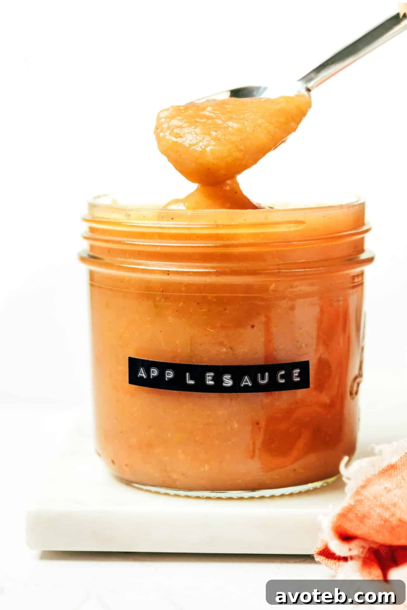A person holding a spoon with fresh Instant Pot applesauce