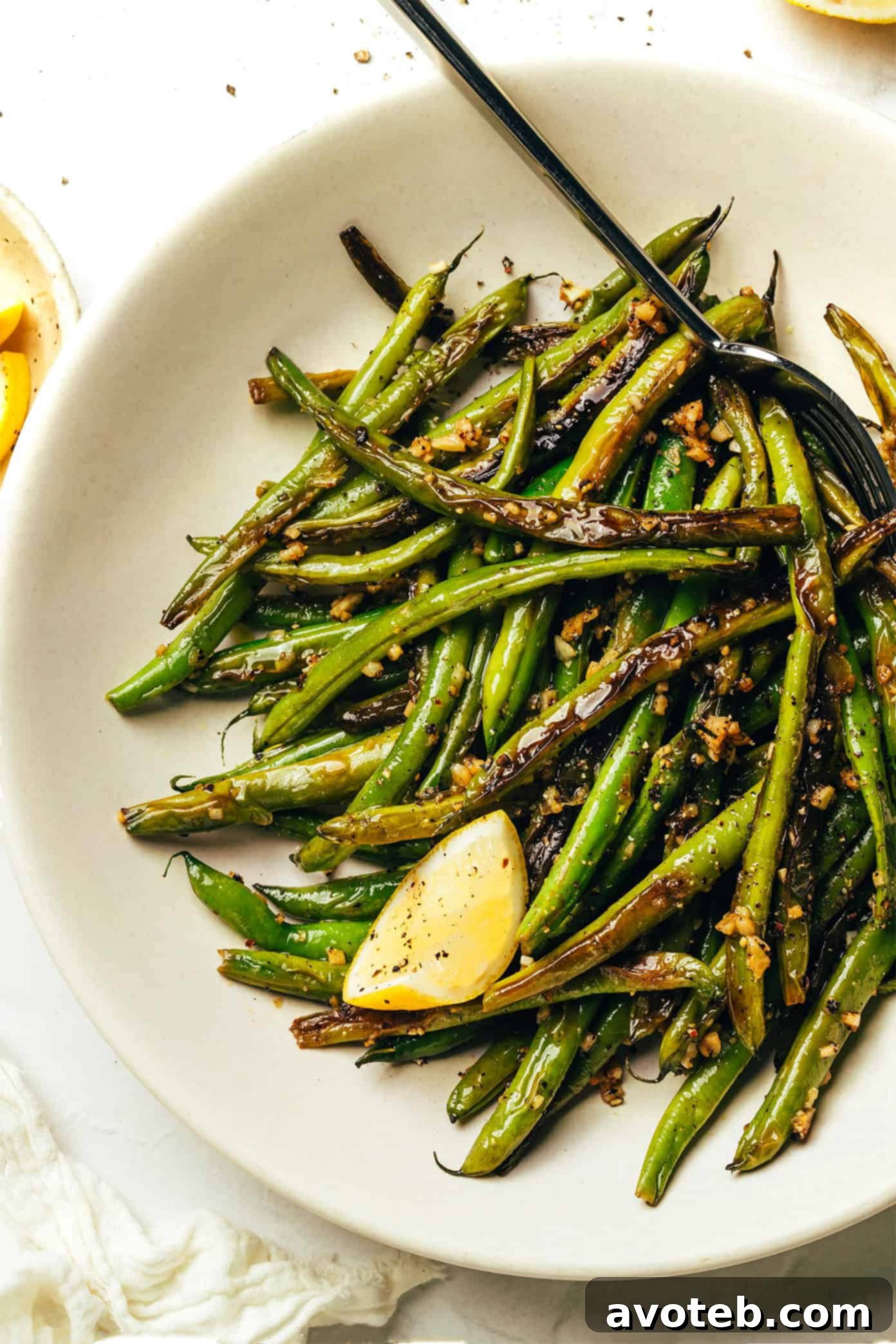Close-up of perfectly blistered green beans with garlic and lemon