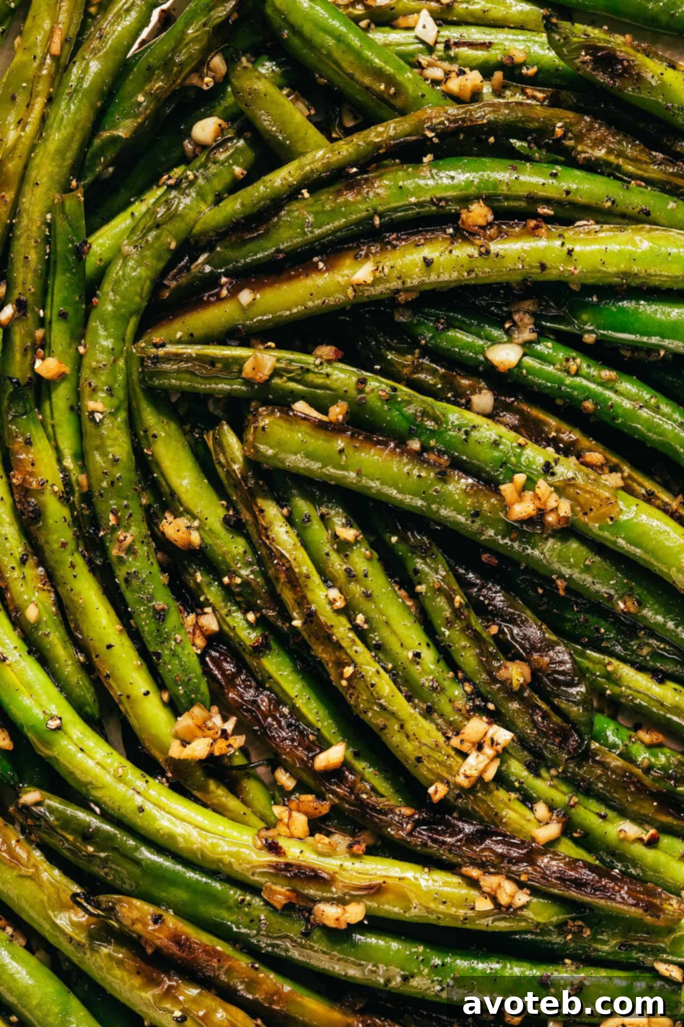 Close-up of a serving of garlic green beans with lemon on a plate
