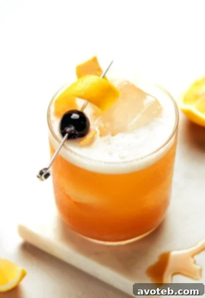 Amaretto Sour cocktail in a glass with lemon and cherry garnish