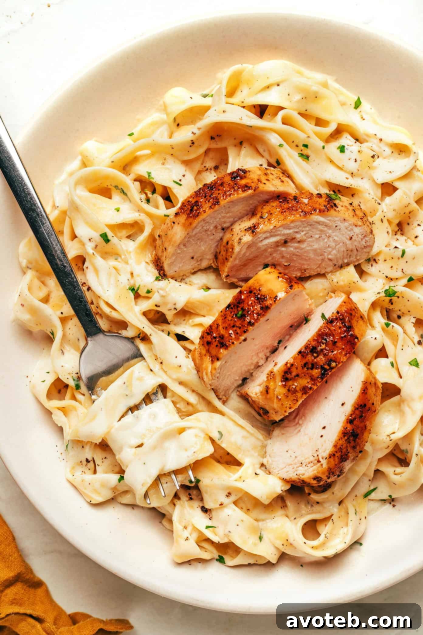 Chicken Fettuccine Alfredo served in a bowl, showcasing creamy pasta and pan-seared chicken.