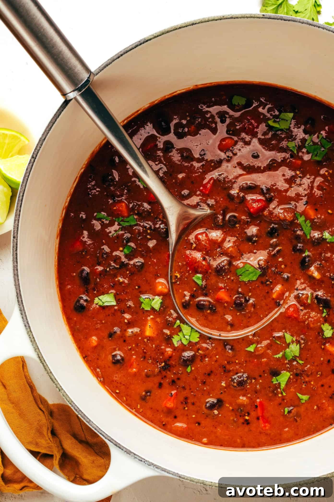 A close-up of hearty black bean soup bubbling gently in a large Dutch oven