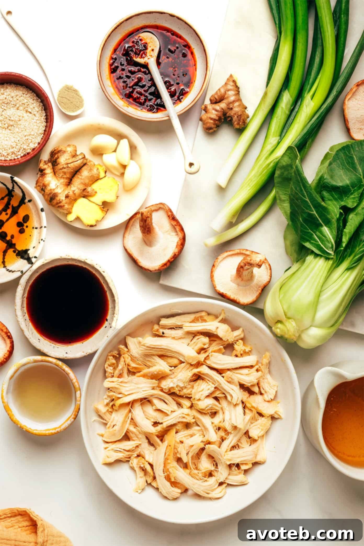 Close-up shot of ginger scallion chicken soup ingredients, including fresh bok choy, shiitake mushrooms, and scallions.
