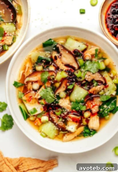 Ginger Scallion Chicken Soup in a bowl with ingredients around it