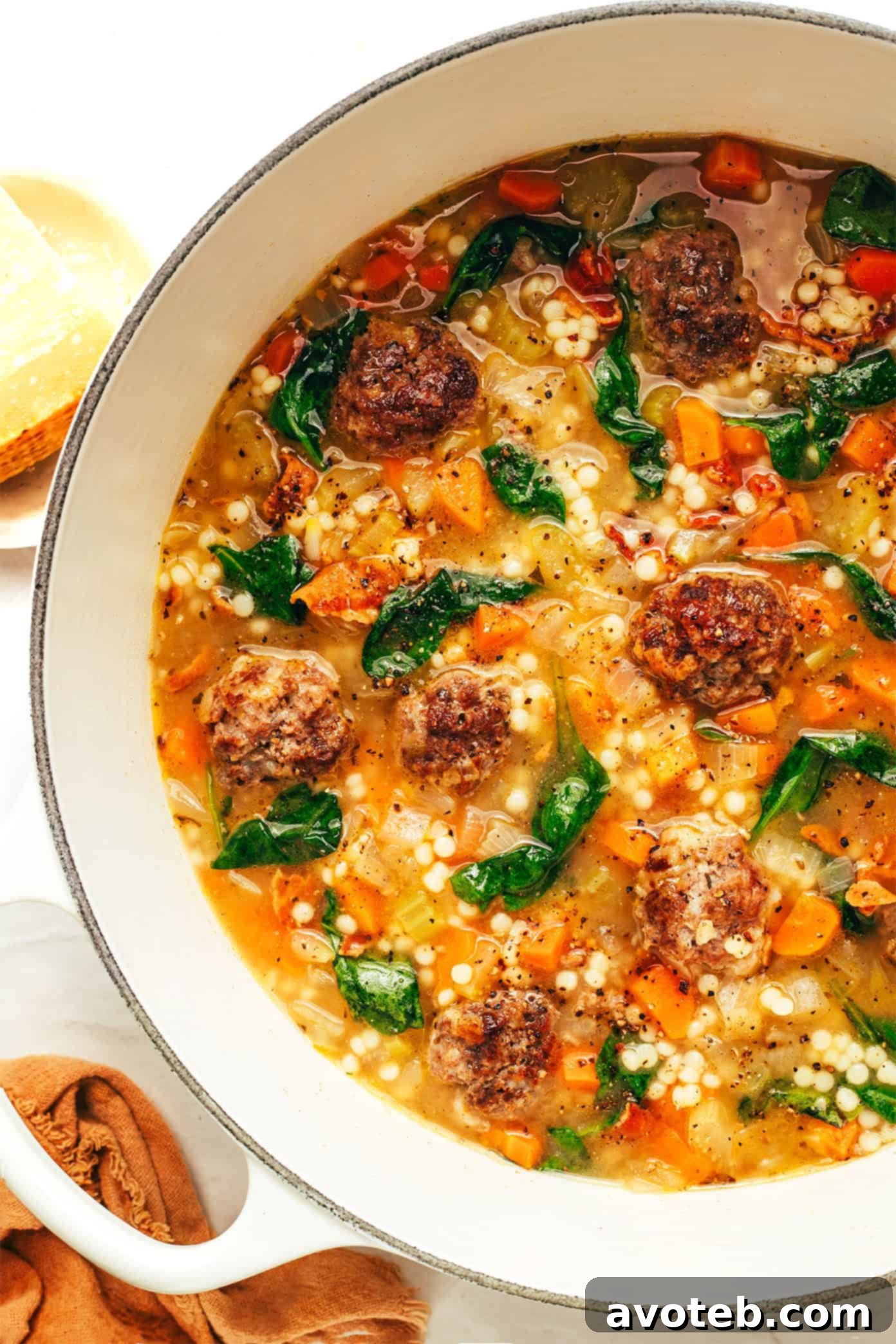 Authentic Italian Wedding Soup 5 A large pot of Italian Wedding Soup simmering on the stove, filled with meatballs, pasta, and vibrant green spinach.