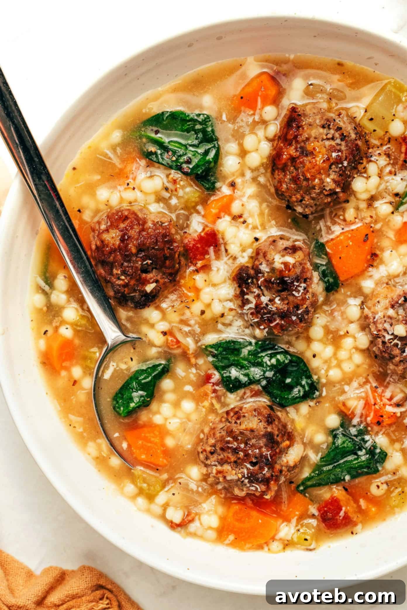 Authentic Italian Wedding Soup 7 Six bowls of various comforting soups, including Italian Wedding Soup, arranged on a rustic wooden table.