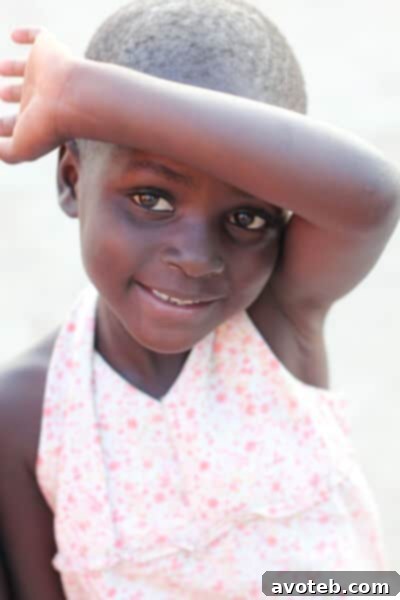 A young girl, Aggie, smiling brightly at the camera.