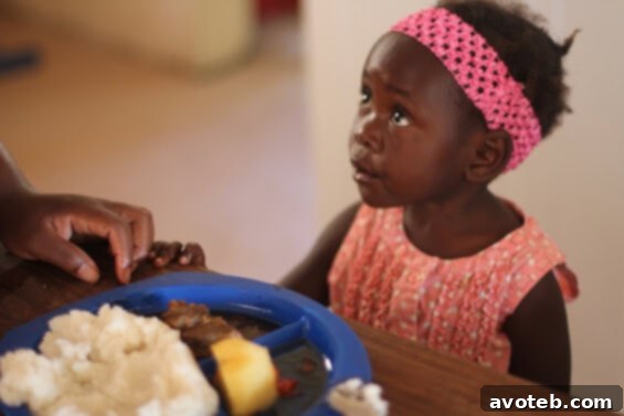 Sweet little Ruth enjoying her first meal at the orphanage, a bowl of porridge.
