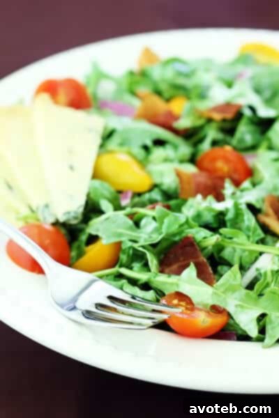 Close-up of Arugula Salad with Bacon, Tomatoes, and Buttermilk Dressing, showing vibrant ingredients