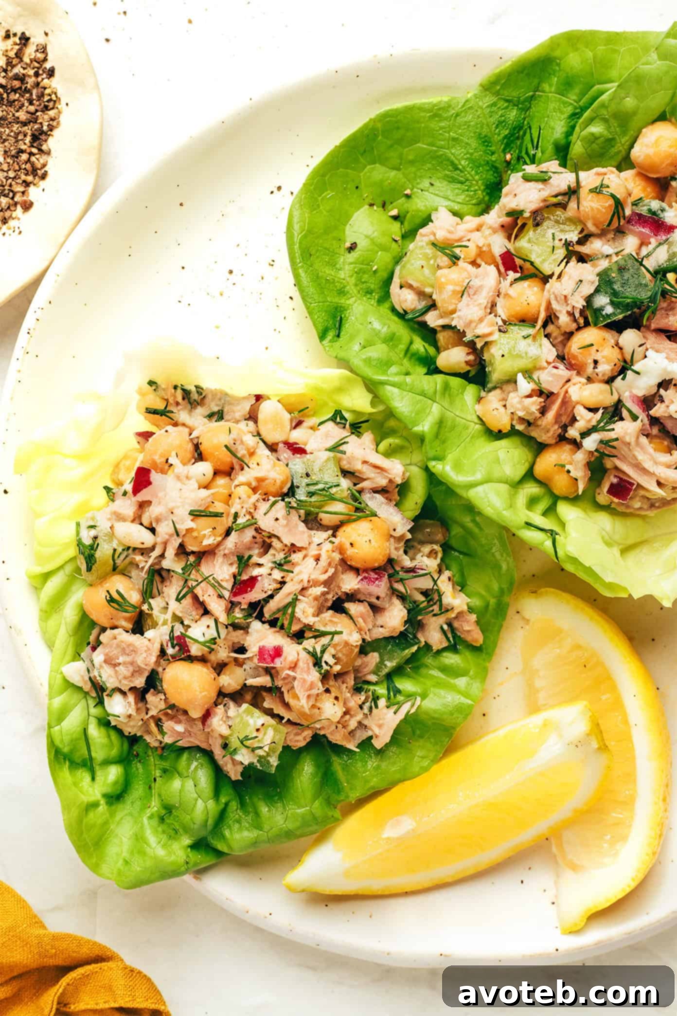 Ingredients for adding to the salad, including a bowl of arugula, capers, sun-dried tomatoes, avocado slices, and crushed pita chips.
