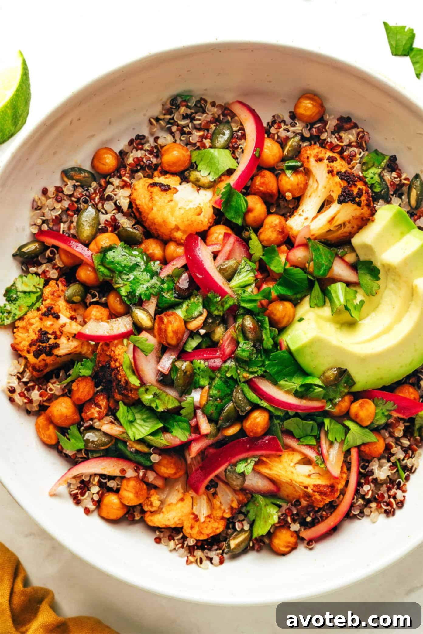 Delicious Chili-Lime Roasted Cauliflower, Chickpea, and Quinoa Bowl topped with fresh cilantro and avocado