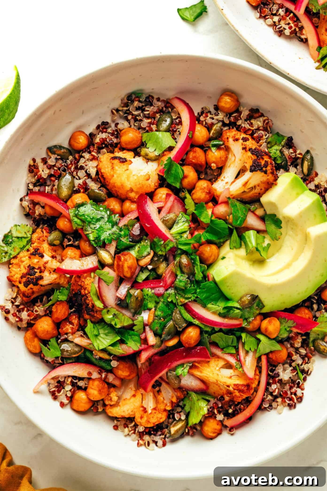 Chili-Lime Roasted Cauliflower, Chickpea, and Quinoa Bowls with fresh avocado slices and cilantro