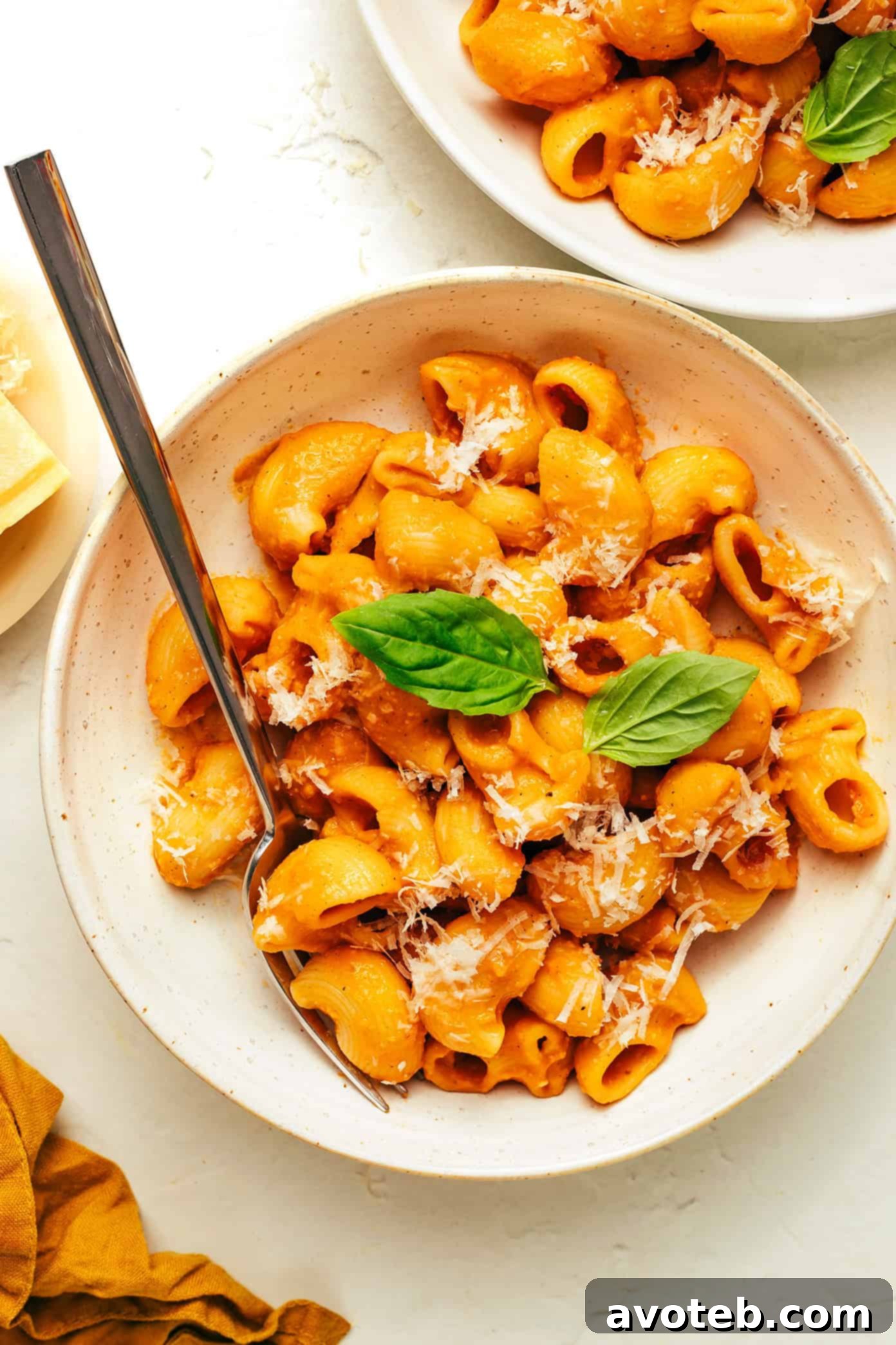 A close-up of a serving of pasta with hidden veggie marinara, garnished with fresh basil, showcasing the appealing texture and color of the sauce.