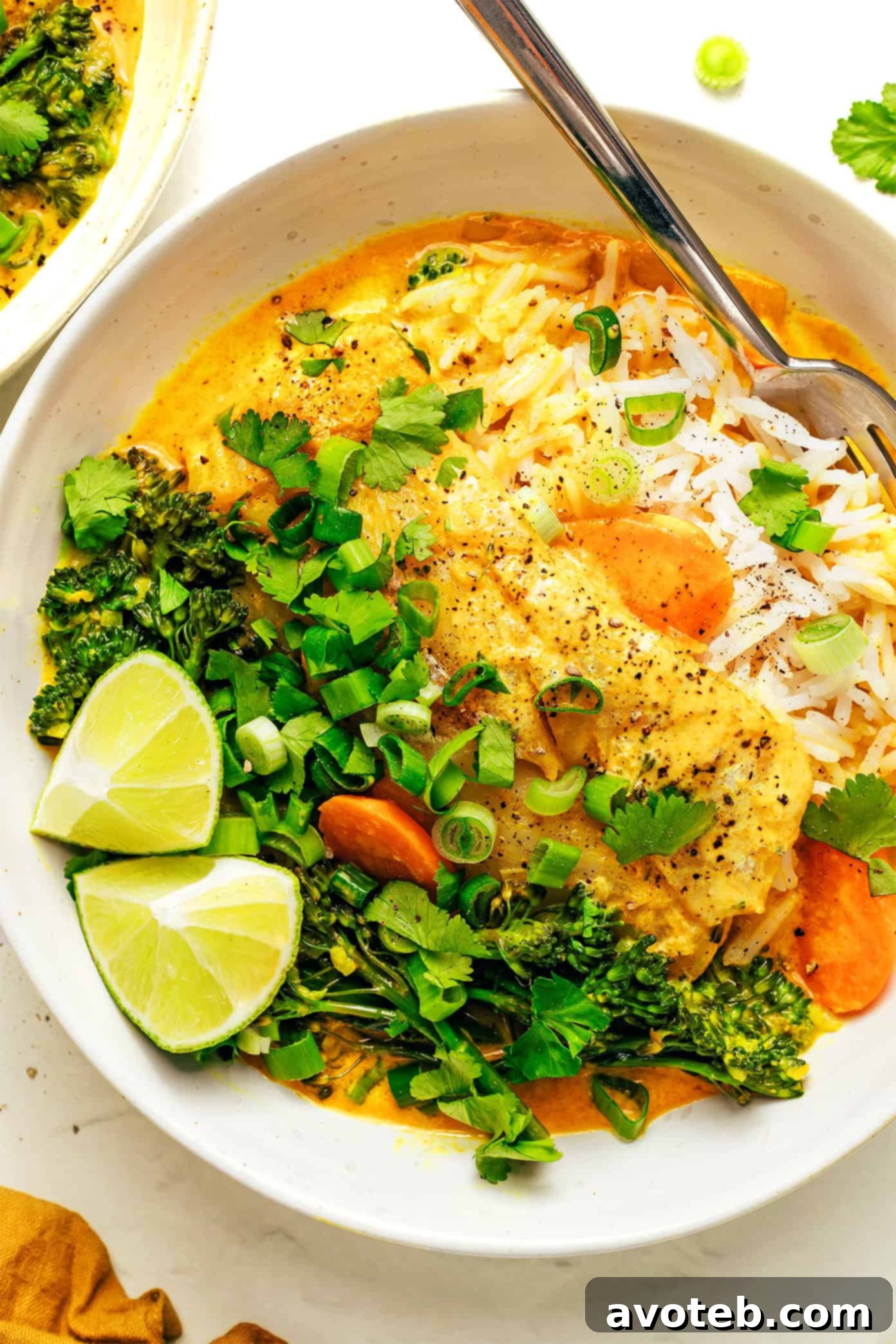 A bowl of Thai Fish Curry served with rice and lime