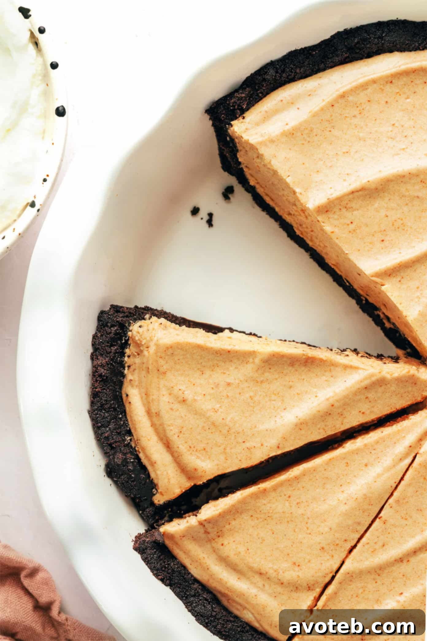Decadent Peanut Butter Dream Pie 2 A beautifully presented no-bake peanut butter pie with an Oreo crust, ready for slicing. The dark chocolate crust contrasts perfectly with the light, fluffy peanut butter filling, hinting at its rich flavor.