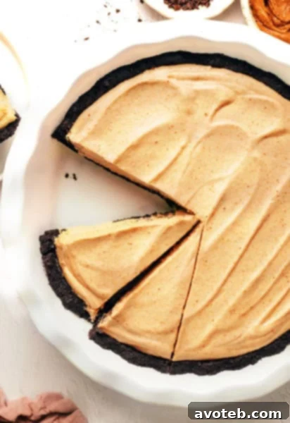 A close-up of a complete no-bake peanut butter pie, rich with its Oreo base and smooth, creamy peanut butter filling, ready to be enjoyed.