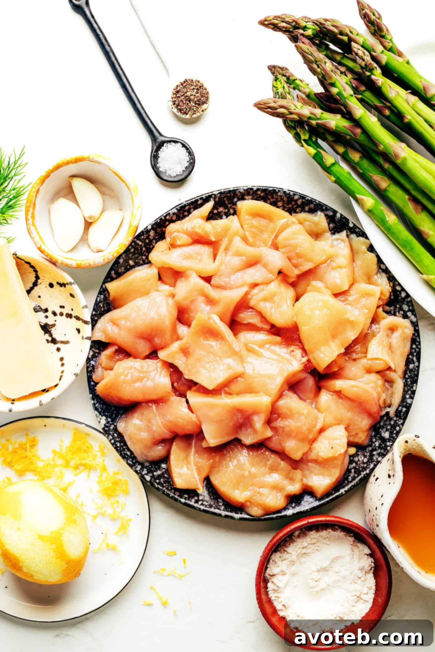 Close-up of lemon pepper chicken and asparagus stir-fry in a pan, with a spoon taking a serving.
