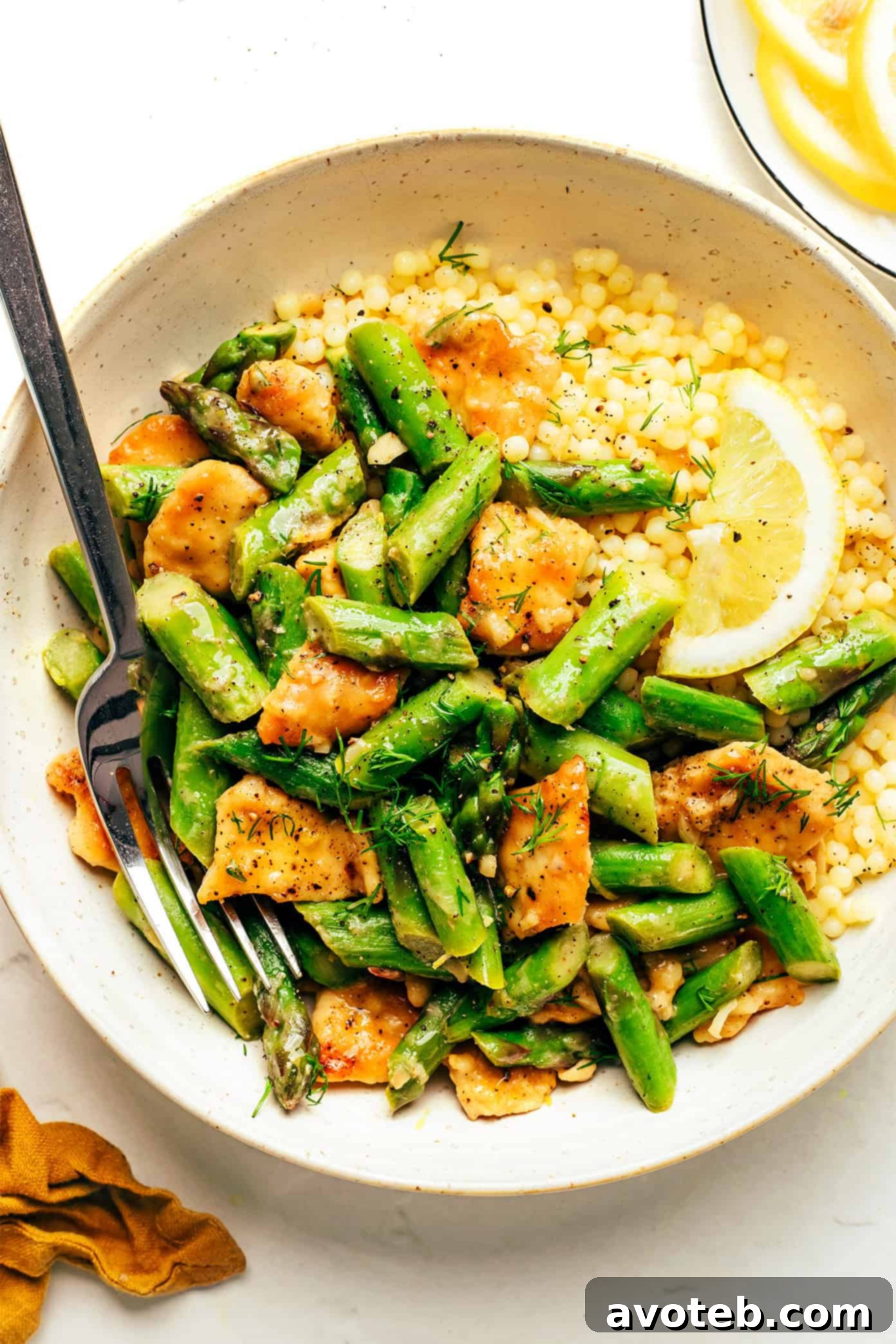 Overhead shot of lemon pepper chicken and asparagus stir-fry in a skillet.