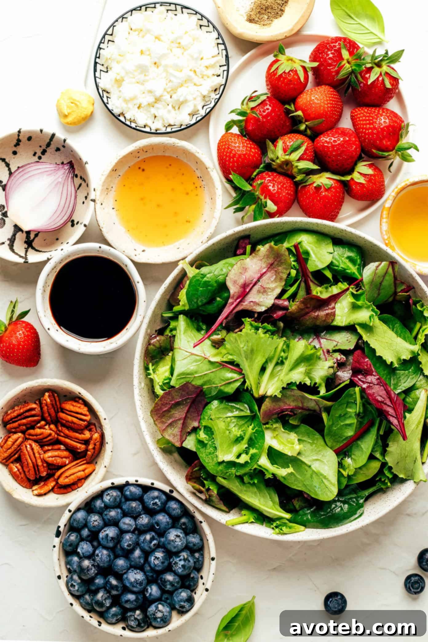 Close-up of balsamic berry spinach salad with juicy berries and fresh basil.