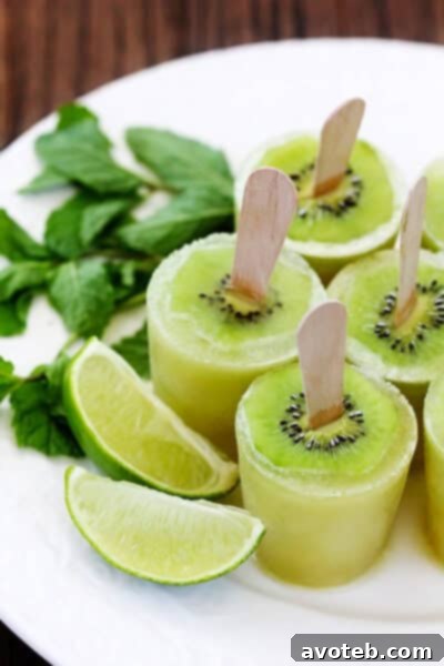 A vibrant green Kiwi Mojito Popsicle, prominently featuring a slice of fresh kiwi embedded near the top, standing upright on a clean white background. A perfect summer refreshment.