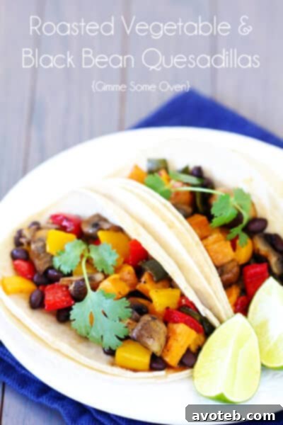 A vibrant platter of fresh ingredients for Roasted Vegetable & Black Bean Tacos, including roasted veggies, black beans, tortillas, and various toppings