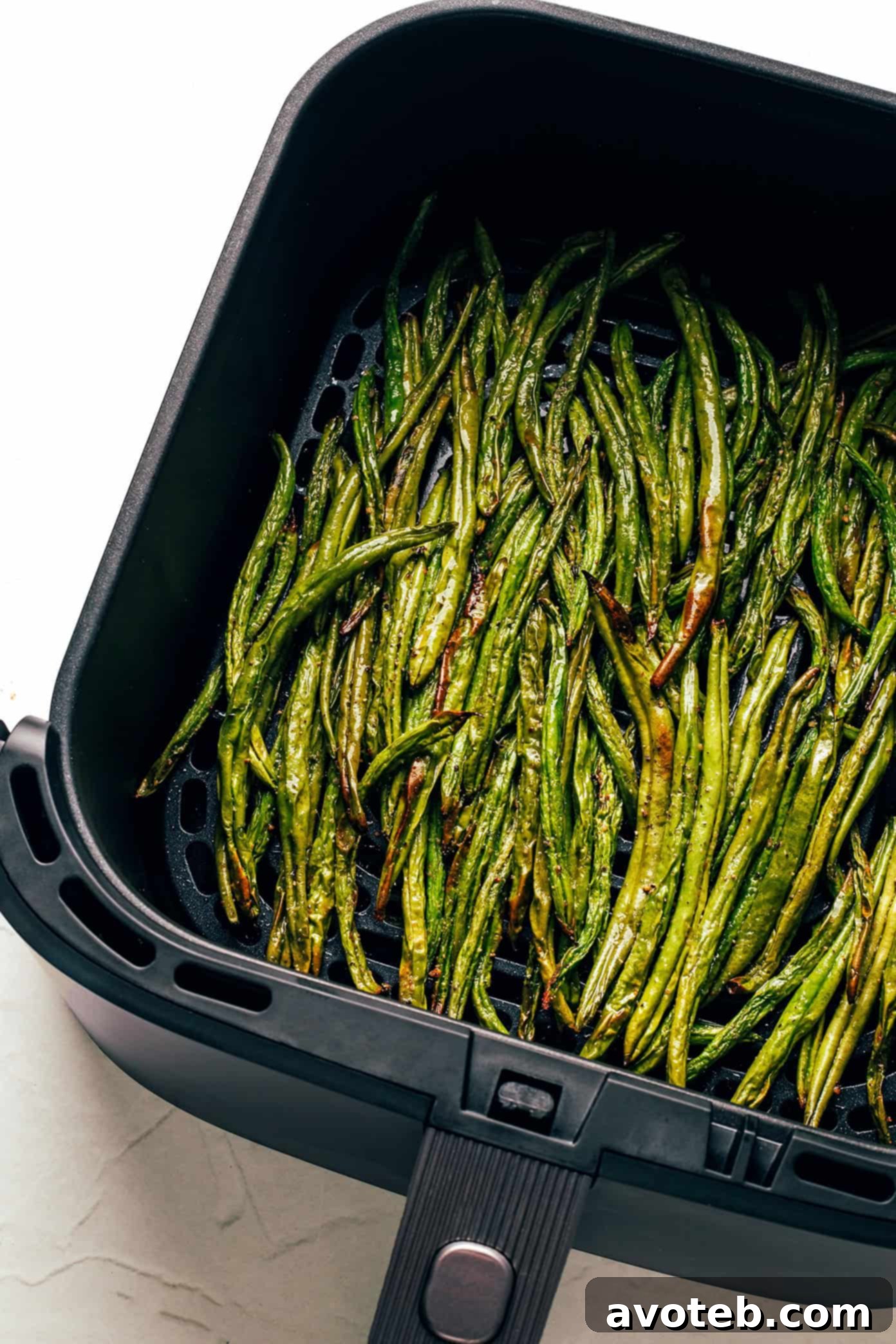Three bowls of air fried green beans with different toppings