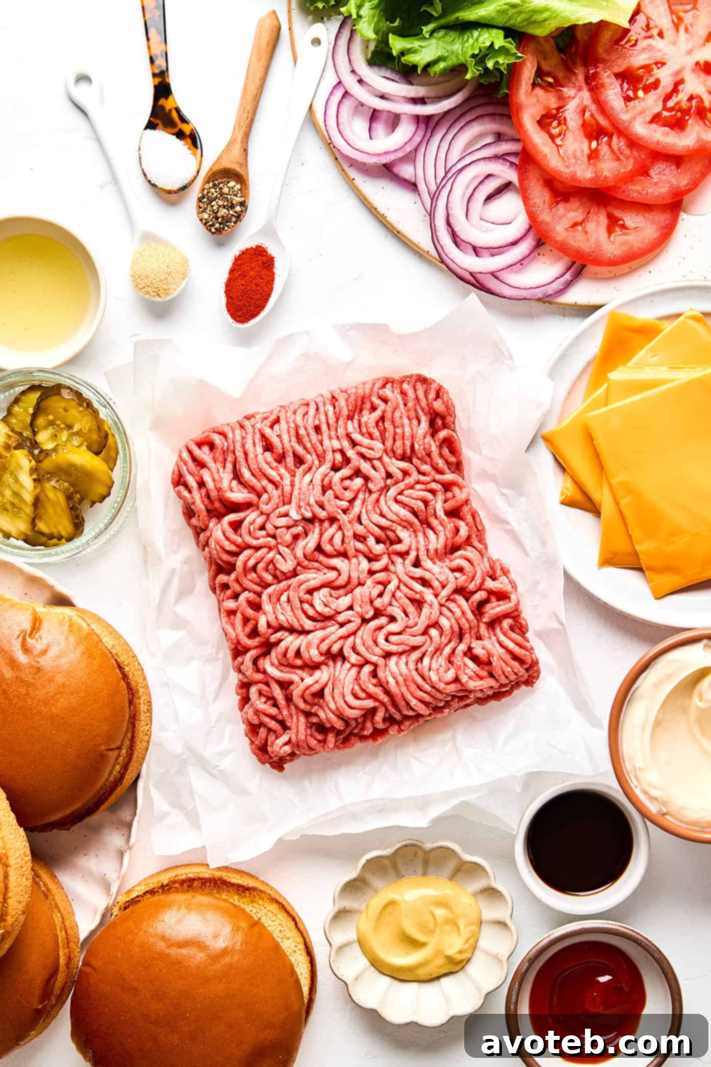 Ingredients laid out for making smash burgers, including ground beef, spices, cheese, and buns.