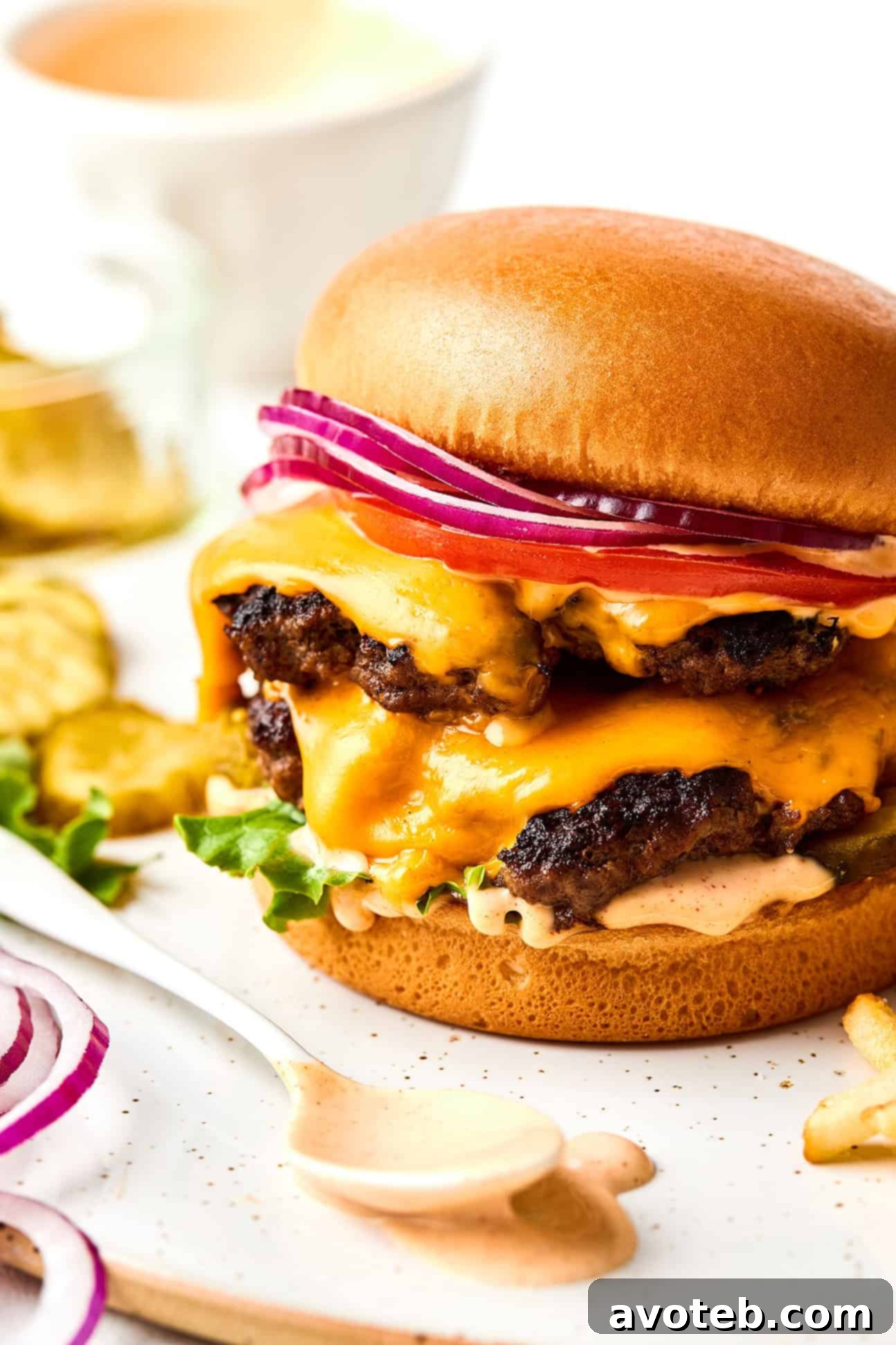 A finished smash burger with melted cheese and burger sauce oozing out, presented beautifully.