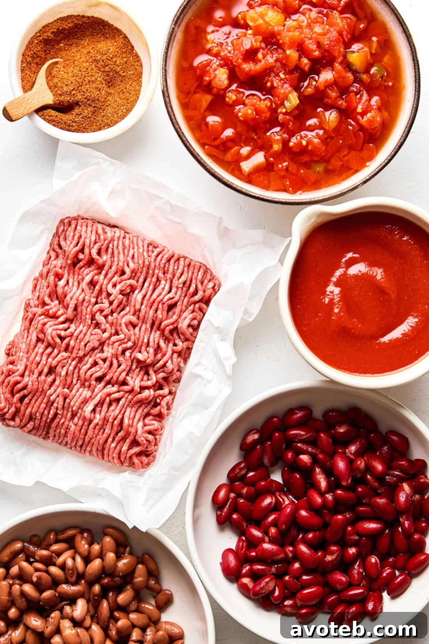 Five key ingredients for the easy chili: ground beef, two cans of beans, two cans of diced tomatoes with green chiles, one can of tomato sauce, and a measure of taco seasoning.