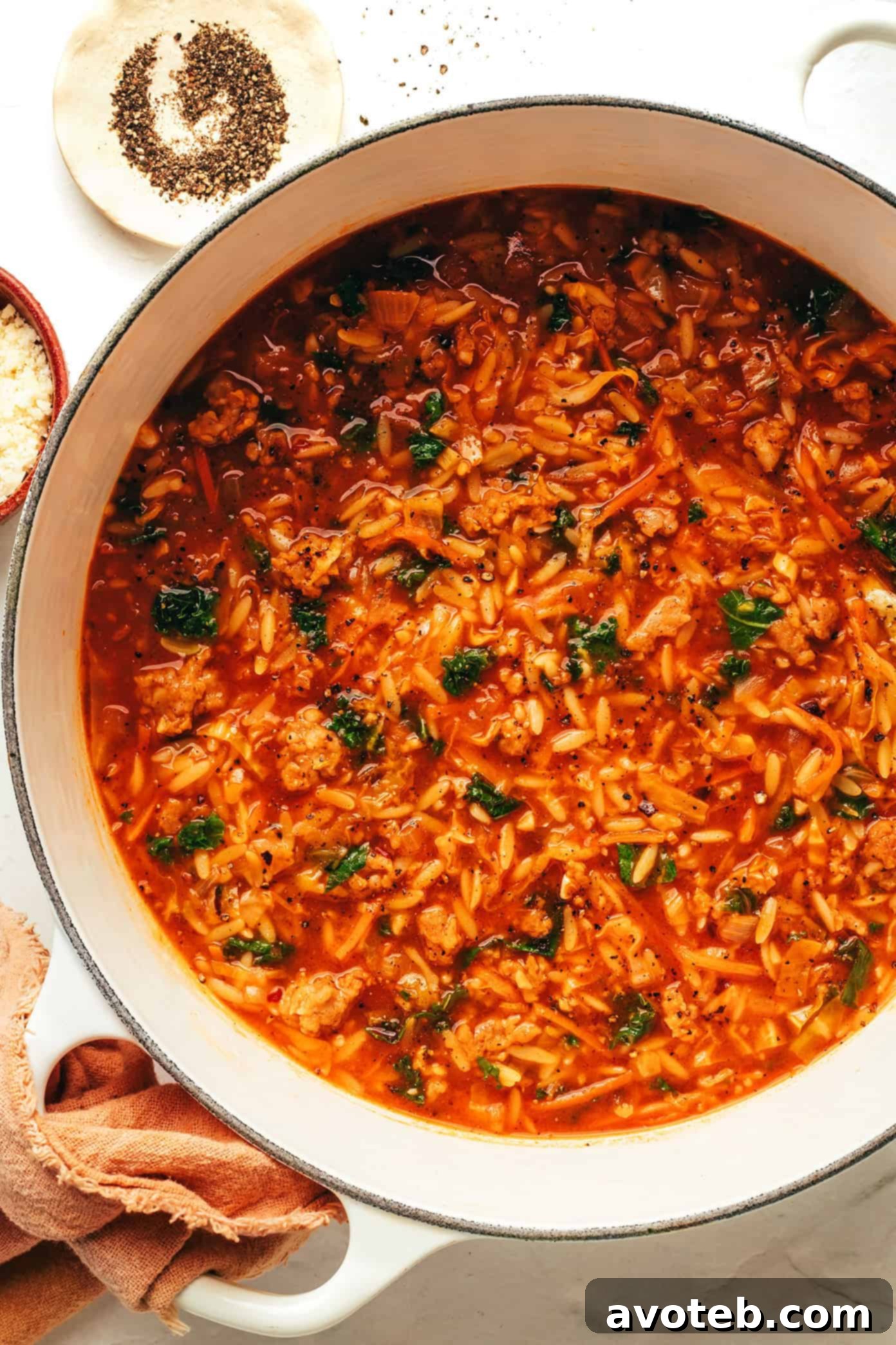 A large bowl of Cabbage Sausage Orzo Soup, garnished with fresh parsley and a sprinkle of Parmesan.