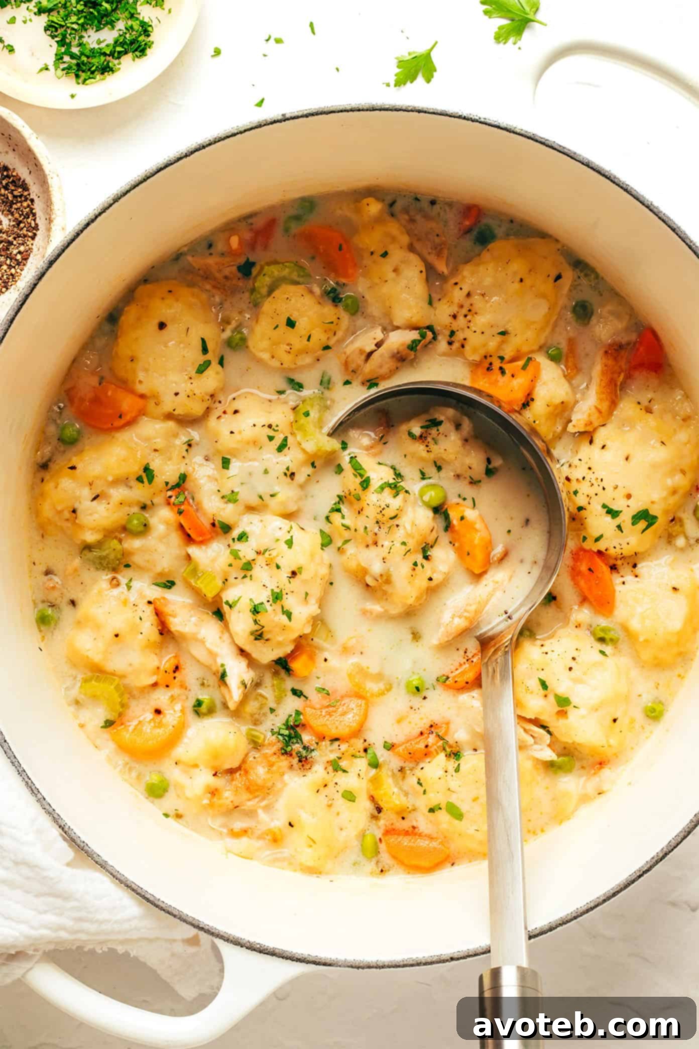 Large pot filled with simmering chicken and dumplings, ready to be served