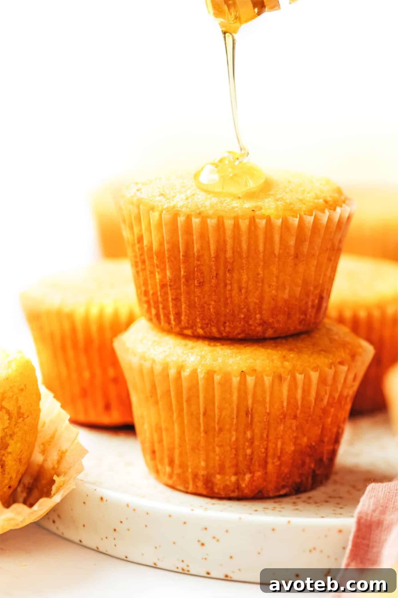 A stack of warm cornbread muffins on a plate