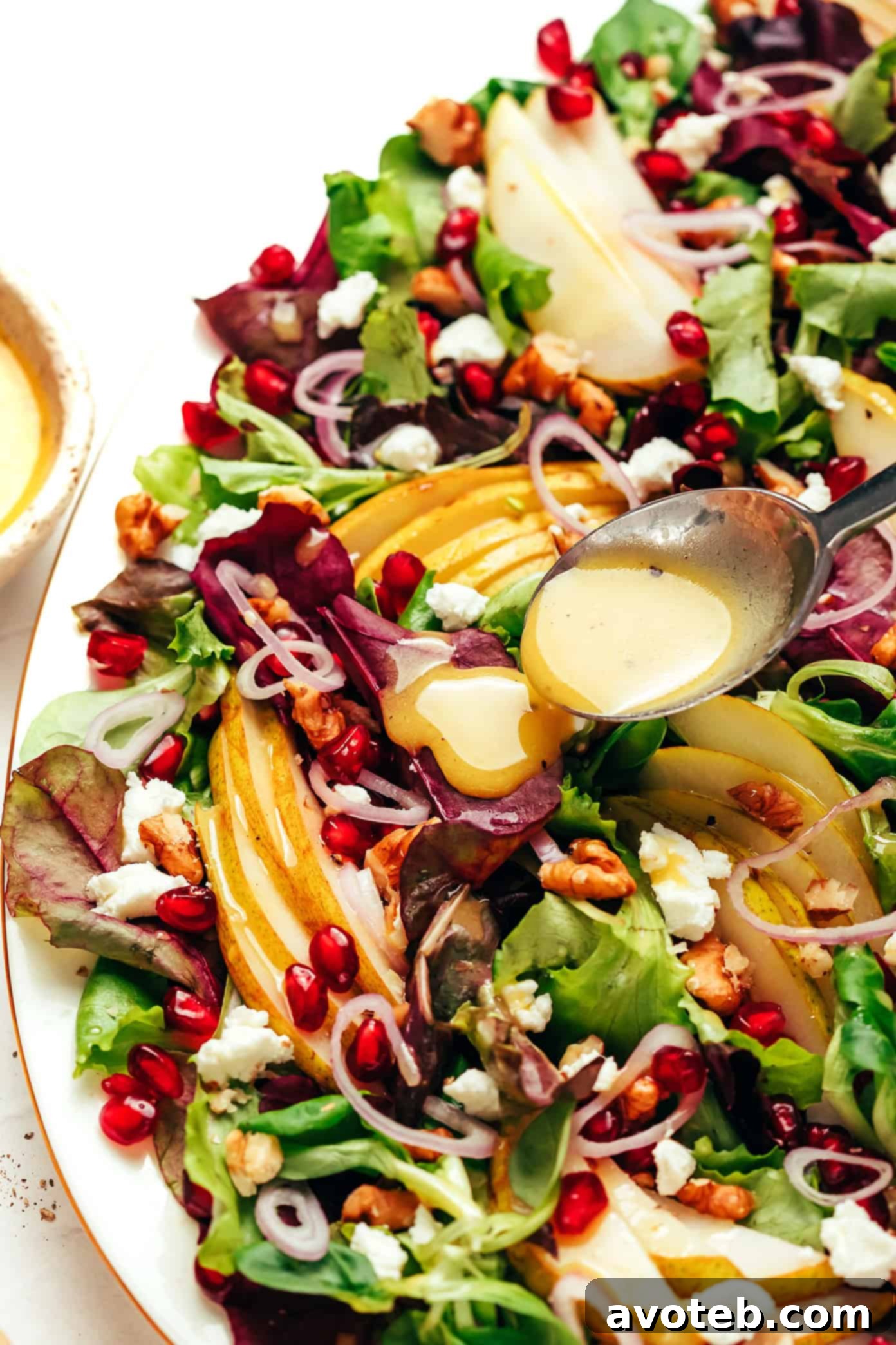 drizzling white balsamic vinaigrette on pear salad