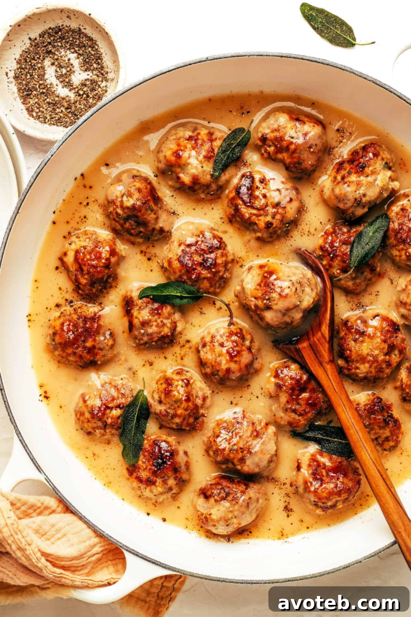 Hearty Turkey Meatballs Smothered in Gravy 5 Close-up of a turkey meatball with a sprinkle of fresh herbs, showcasing its tender texture and rich gravy coating.