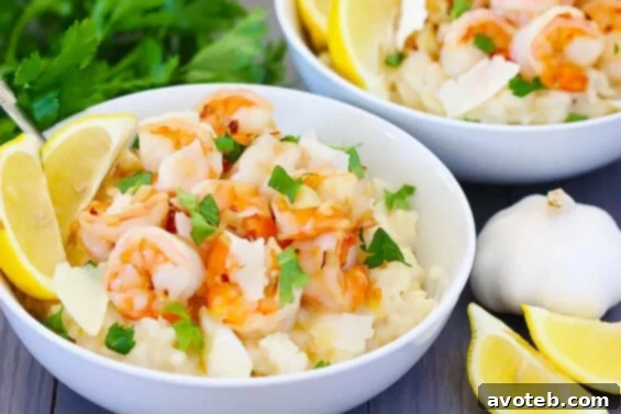 Shrimp Scampi With Parmesan Risotto, garnished with fresh parsley and lemon wedges, on a white plate