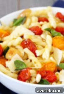 A serving of Slow-Roasted Tomato, Garlic & Parmesan Pasta with fresh basil and pine nuts