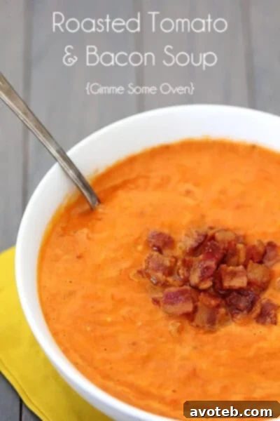 A beautifully presented bowl of Roasted Tomato Bacon Soup, garnished with fresh herbs and a slice of crispy bacon, inviting enjoyment.