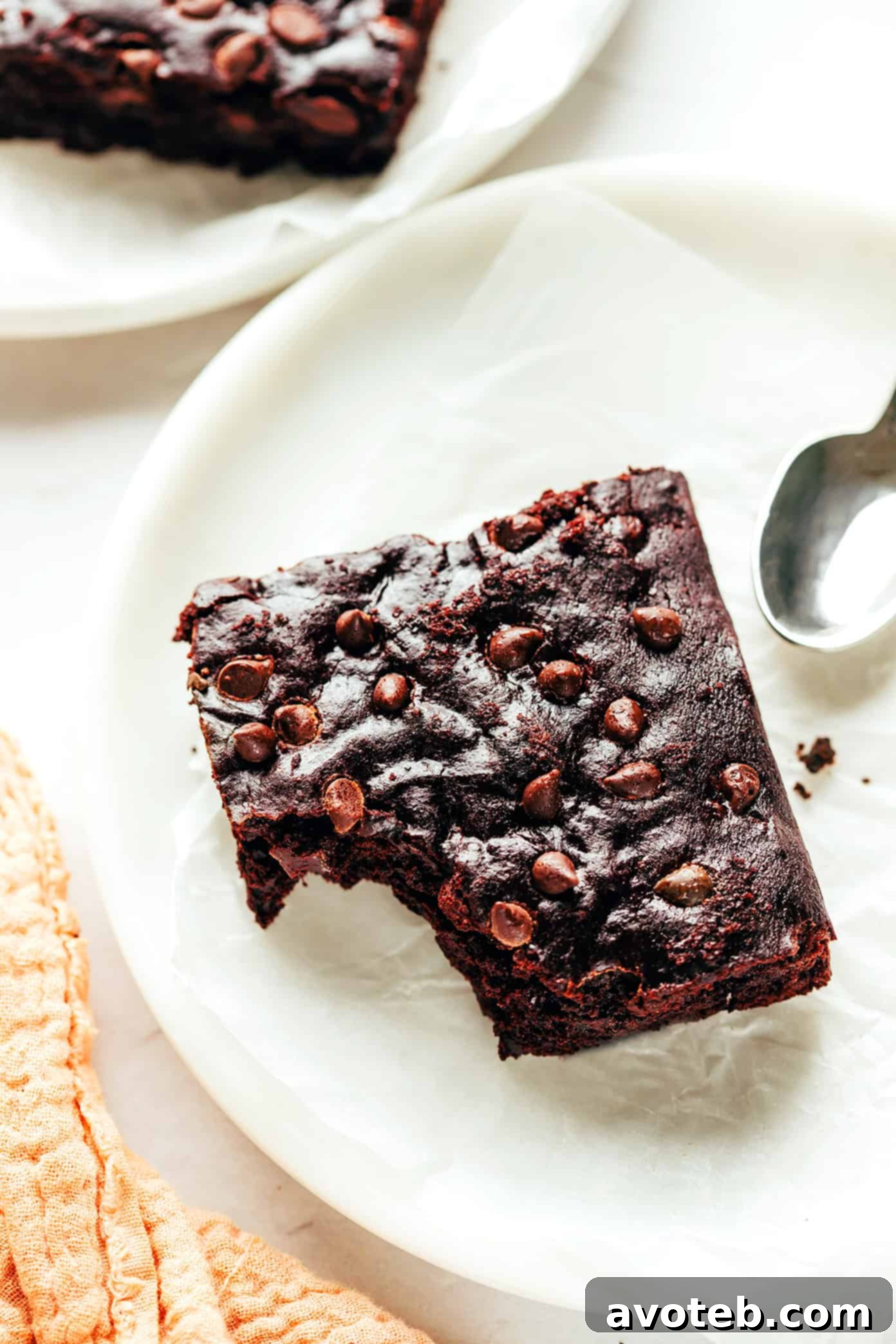 A plate of vegan brownies served with fresh berries and powdered sugar.